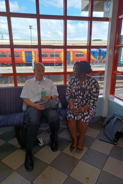 Two people sitting talking in platform waiting room